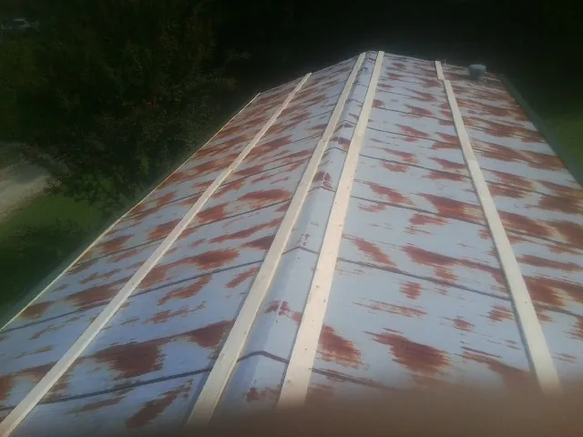Rusted metal roof panels with new wood purlins before replacement — Storm Damage Roof Repair in Newkirk by Roofing Brothers