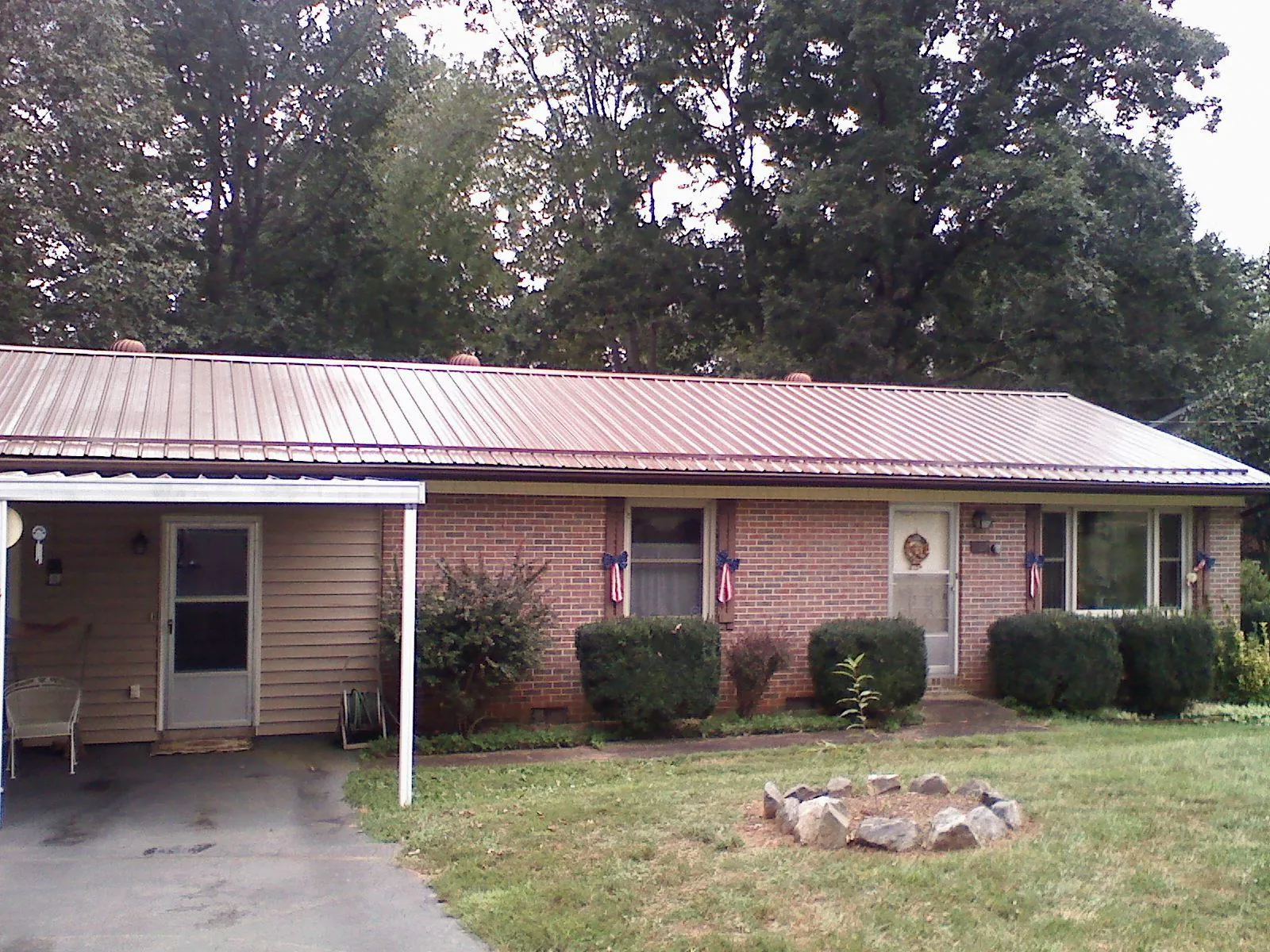 Bronze metal roof and carport on a brick ranch home — Roof Repair work by our crew in Newkirk